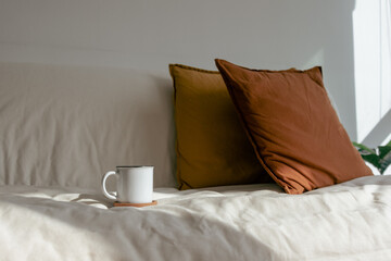 Fototapeta na wymiar White coffee cup on the sofa in concept of resting and relax.