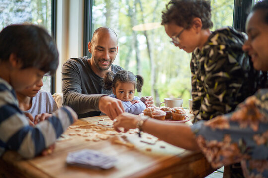 Family playing scrabble at dining table