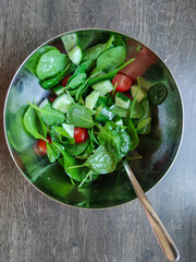 Top view of green healthy salad with other colorful vegetables such as cherry tomato and cucumber
