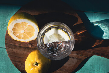 Water with lemon on a turquoise wooden background. Drink with vitamin C. Detox drink