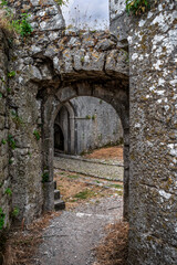 Fototapeta premium Ancient stone walls with arched passage in Rozafa Castle in Shkoder, Albania. Inner courtyard of a medieval ruined fortress, vertical
