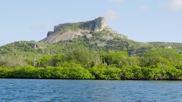 The iconic Tafelberg mountain on the Caribbean island of Curacao with a mangrove forest and ocean below. Truck shot