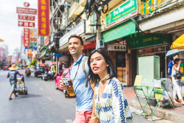 Happy multiracial couple or friends exploring China town in Bangkok