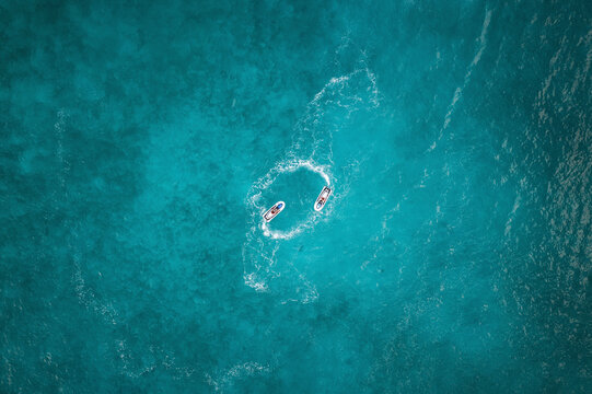 Aerial View Of People Circling Around On Jet skis Over Blue Ocean Waves In Male, Maldives.