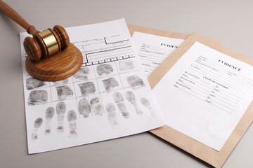 Judges gavel, fingerprint cards and paper envelopes to pack evidence.