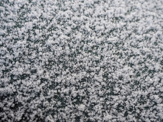 Snowflakes, snow crystals on the car roof. Freeze, frost, macro