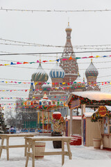 Moscow, Russia, February 7, 2022, Red Square covered with snow in winter, view of St. Basil's Cathedral. Photo of Russian winter in white colors. Winter cafe outside, fair on Red Square.
