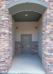 Vertical Facade of an entrance of a townhouse with brown stone bricks