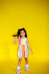 Funny little girl about 6 years old in casual summer clothes posing on a plain yellow background....