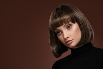 Portrait of a beautiful brown-haired woman with a short haircut on a brown background