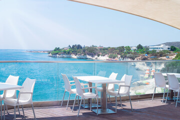 A cafe restaurant on the shores of the Mediterranean Sea. Tables on the terrace in the rays of the sun.