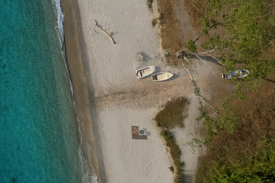 Aerial view of a beach with boat rentals surrounded by lush forest in Isca sullo Ionio, Calabria, Italy.