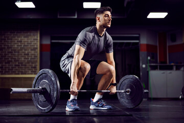 Fit sportsman doing deadlift at the gym and practicing functional training.