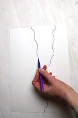hand drawing with purple marker and random wave line on white paper