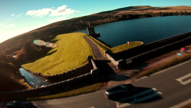 Aerial drone shot of Brecon Beacons with reservoir at the botom next to pen y fan peak. Drone video of fast flowing fpv view wales uk