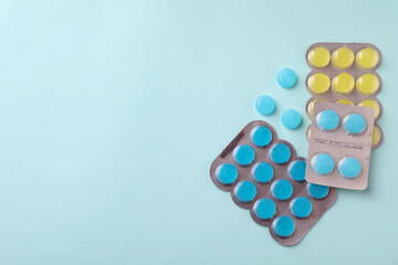 Colorful cough drops on light blue background, flat lay. Space for text