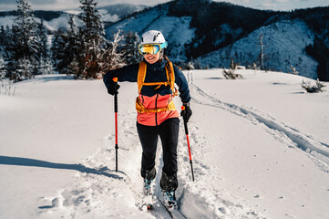 Mountaineer backcountry ski walking ski woman alpinist in the mountains. Ski touring in alpine...