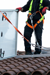 Técnico instalando placas de energía renovable en tejado de chalet. 5