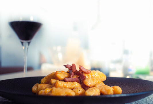 Piatto di gnocchi di zucca con speck