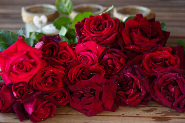Ramo de rosas rojas sobre mesa de madera.