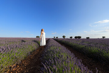 Female in white dress breathing in a lavender field