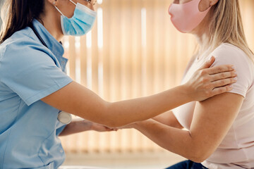 A female doctor in doctor's office talking to a sick woman.