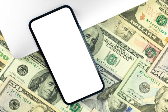 Business smartphone mockup. Office desktop with laptop and money dollar bills background, top view, copy space photo
