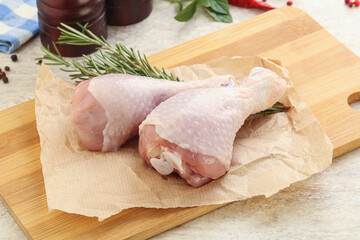 Raw chicken leg over board