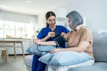 Asian caregiver doctor examine older patient use blood pressure gauge. 
