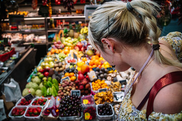 Asian woman choosing fruits in market