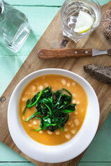 White beans with spinach. Legumes and vegetables. Healthy dish with vegan protein. Plant based food.