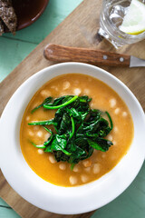 White beans with spinach. Legumes and vegetables. Healthy dish with vegan protein. Plant based food.