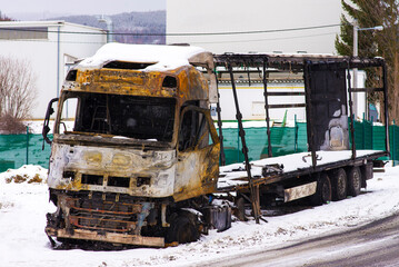 Burnt out truck in snow by the road side. Tractor and trailer completely damaged by fire and flames