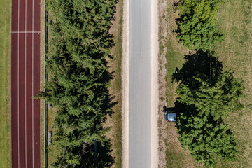 Luftbild einer Straße parallel verlaufend zu einer Aschenbahn
