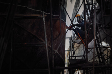 Local Asian worker in shipyard for maintenance.Real situation of Asian local factory,concept of industrial worker life.
