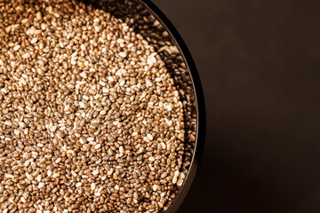 Chia seeds in bow close-up, top view