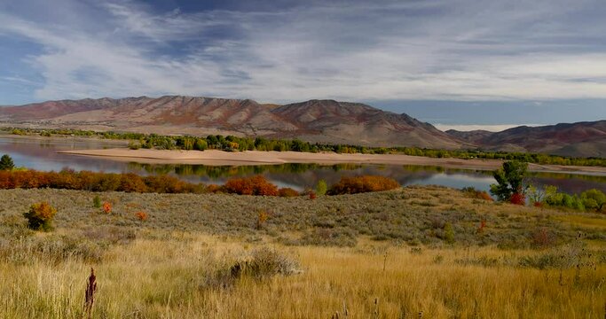 Scenic landscape Pine view reservoir recreation area in Utah during autumn time, surrounded with tall grass colorful bushes and mountains