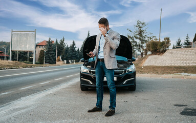 Elegant middle age business man calling towing service for help on the road. Roadside assistance...