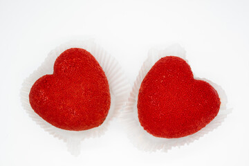 A bright red heart-shaped cakes on a white background. Copy space