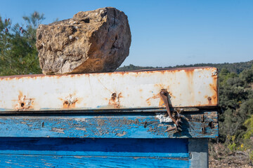 Detalle colmena vieja con abejas entrando por la tapa