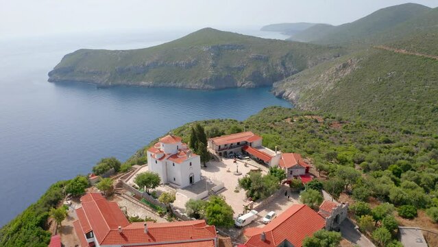 4k drone flight moving to the side footage (Ultra High Definition) of Moni Evaggelistrias church. Aerial summer scene of Peloponnese peninsula, Greece. Beautiful seascape of Mediterranean sea.