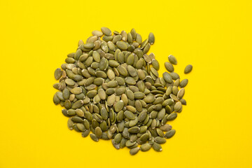 Pumpkin seed on a yellow background close-up.