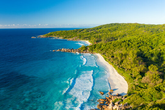 Panoramic aerial view of a scenic beach with white sand facing Anse Cocos Bay, La Digue and Inner Islands, Seychelles.