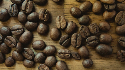 Many coffee grains, beans on brown table as background