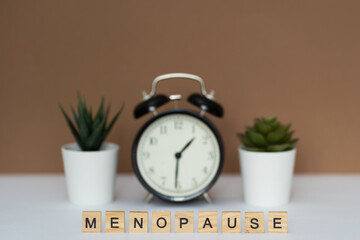 Concept. The inscription from the letters menopause. Symptoms of Menopause Harmonious changes in...
