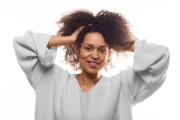 Smiling 30 year old African American woman holding her hands in her hair, smiling and looking at the camera - concept of psychology and women's health.