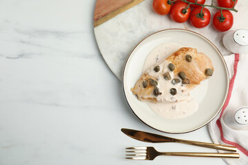 Delicious chicken fillet with capers and sauce served on white table, flat lay. Space for text