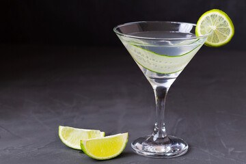 cucumber martini with lime.Cucumber water with lime. martini glass of lemonade on the black table....