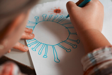 Cute little girl holds her drawing molecule Corona virus Omicron. World health coronavirus outbreak...