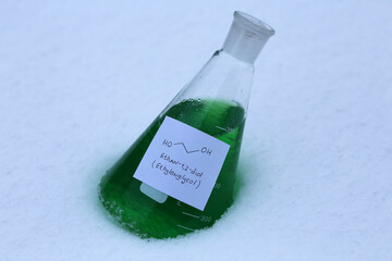 Green ethylene glycol in a conical flask on the snow. The main raw material for the production of...